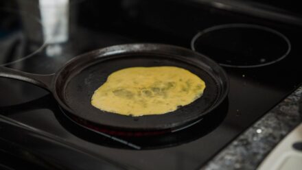 김치전 반죽 농도를 조절하며 앞뒤로 부쳐지는 장면