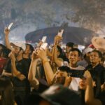 사람이 스마트폰에서 축구 경기 티켓을 확인하고 경기장 출입구로 이동하는 장면