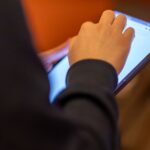 중고 태블릿 터치 문제를 확인하는 사용자가 강화유리와 캘리브레이션을 점검하는 장면