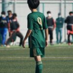 축구 선수가 겨울 이적 후 경기장 옆에서 유니폼을 들고 있는 장면