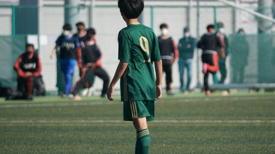 축구 선수가 겨울 이적 후 경기장 옆에서 유니폼을 들고 있는 장면