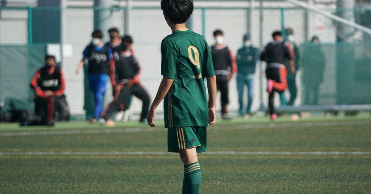 축구 선수가 겨울 이적 후 경기장 옆에서 유니폼을 들고 있는 장면